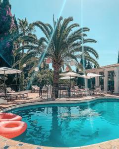 马贝拉贾迪勒斯女王精品B&B酒店的一个带棕榈树和桌椅的游泳池