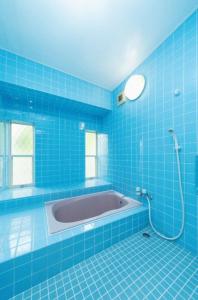 淡路ANJIN STAY AWAJI - Vacation STAY 83766的蓝色瓷砖浴室设有浴缸和淋浴。