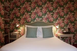 塞莱斯塔普雷斯·道丁酒店的卧室配有一张墙壁上粉红色鲜花的床。