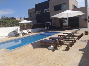 科马鲁加Casa Can Miras的一个带躺椅和遮阳伞的游泳池