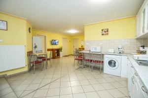 豪伊杜索博斯洛Betty Apartman Hajdúszoboszló的厨房设有黄色的墙壁和洗衣机。