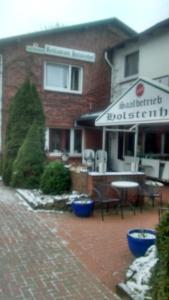 SchmalfeldHolstenhof"garni"的一座带桌椅的庭院的建筑