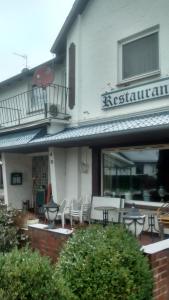 SchmalfeldHolstenhof"garni"的大楼前设有桌椅的餐厅