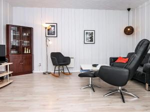 罗莫柯克比4 person holiday home in R m的客厅配有两把椅子和一张沙发