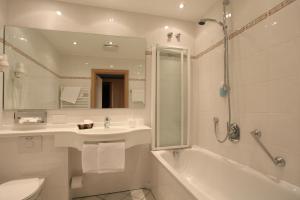 基青根艾斯巴赤豪弗酒店-餐厅的带浴缸、盥洗盆和卫生间的浴室