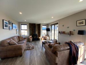 特威泽尔Pedalfish Cottages - Galaxy Views的客厅设有两张沙发和一个壁炉