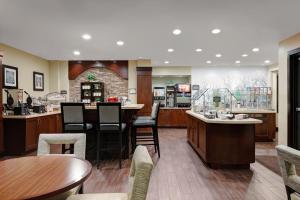 拉纳姆Staybridge Suites Washington D.C. - Greenbelt, an IHG Hotel的餐厅设有酒吧,配有桌椅