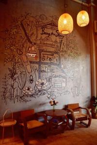 曼谷Bangpho Story的壁画墙,配有桌椅