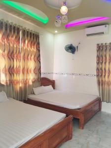 惹岛Lộc An Lý Sơn Motel的配有窗帘和防滑装置的客房内的两张床