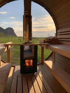 UnnstadUnstad Arctic Resort的小屋内燃木火炉,享有田野美景