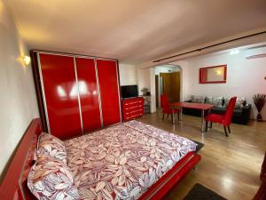康斯坦察Faleză nord的一间带红色床的卧室和一间客厅