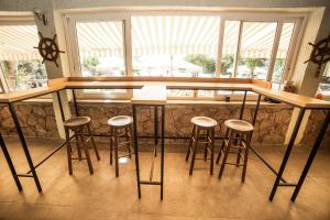 贝拉姆卡尔利盟纳塔阿索斯酒店的厨房设有带凳子和窗户的酒吧