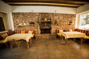 贝拉姆卡尔利盟纳塔阿索斯酒店的一间带两张桌子和石头壁炉的餐厅