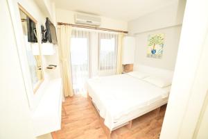 贝拉姆卡尔利盟纳塔阿索斯酒店的白色的卧室设有床和窗户