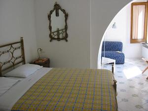 拉维罗Villa Casale Ravello Residence的一间卧室配有一张床、一把椅子和镜子