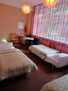 拉脱维亚明霍泽娜武达酒店的酒店客房带两张床和一张桌子以及椅子。