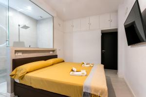 塞维利亚Unique House - Private SPA&Pool -StayInSeville的一间卧室配有黄色的床和电视