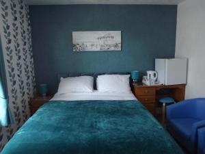 大雅茅斯契克斯酒店的一间卧室配有一张床和一张蓝色椅子