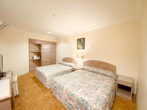 金马仑高原彩虹酒店的酒店客房设有两张床和电视。