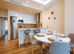 塞维利亚Magno Apartments San Martín Terrace的厨房以及带白色桌椅的用餐室。
