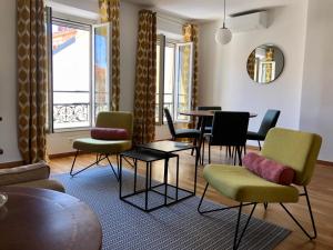 戛纳LE BAIN DE SOLEIL luxury 2 bedrooms Cannes centre的客厅配有椅子和桌子,设有窗户