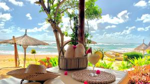 托弗海滩Casa na Praia Tofo- beach front hotel的沙滩上的桌子,带鞋和一杯葡萄酒