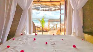 托弗海滩Casa na Praia Tofo- beach front hotel的一间卧室配有一张床,享有海滩美景
