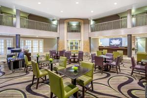 土桑图森机场拉昆塔套房酒店的酒店大堂设有桌椅和钢琴