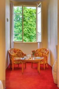 纳雅克L'Oustal Del Barry的客房设有桌子、两把椅子和窗户。