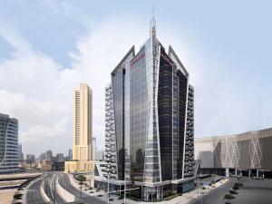 迪拜Mövenpick Hotel Apartments Downtown Dubai的一座高大的玻璃建筑