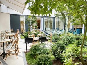 巴黎Maison Albar - Le Vendome的户外庭院设有桌椅和植物