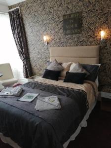 布莱克浦加内特酒店的一间卧室配有一张大床,上面有衣服