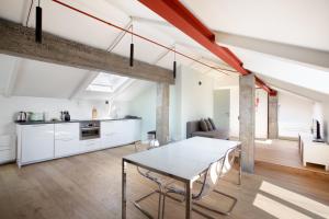 都灵Mato Apartment Torino的厨房以及带桌椅的起居室。