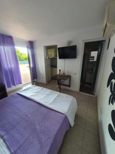 萨图恩Casa Maria Saturn的一间卧室配有一张大床和紫色毯子