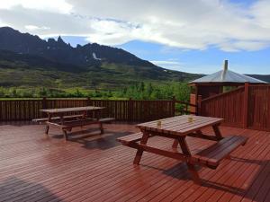 阿克雷里Engimyri Lodge的甲板上设有两张野餐桌和凉亭