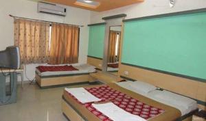 乔斯希马特Hotel Shail Shikhar的客房设有两张床和大屏幕