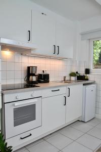 波鸿Apartmenthaus in der Metzstraße的厨房配有白色橱柜和炉灶烤箱。