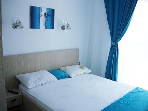北马马亚-讷沃达里Studio Infinity by Alz的一间卧室配有一张蓝色窗帘的床