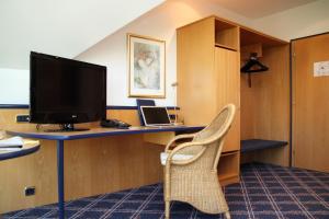 伊斯马宁泽波斯特酒店的客房设有书桌、电视和椅子