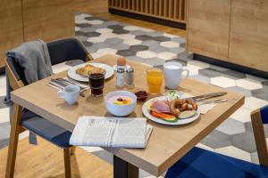 哥廷根Holiday Inn Express - Goettingen, an IHG Hotel的一张木桌,上面放着食物和饮料