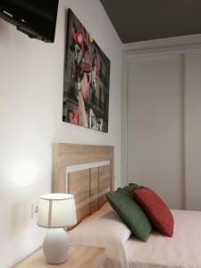贝尼卡洛Estudios Placeta dels Bous - Plaza Constitución的一间卧室配有红色和绿色枕头的床