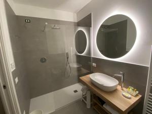 巴多利诺Rooms ai Poggi的浴室配有盥洗盆和带镜子的淋浴