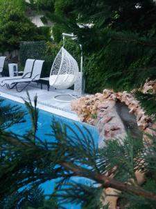 卡尼奥提Pegasus Hotel的一个带两把椅子和秋千的游泳池