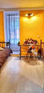 布拉索夫Casa Crown的一间卧室设有黄色的墙壁、一张桌子和一张床