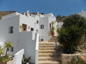 Presillas BajasEn la Majada Redonda的白色的房子,有楼梯和棕榈树