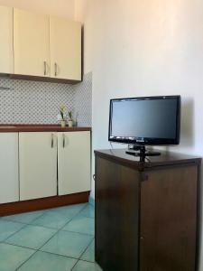 伊斯基亚Residenza Celeste al 28的坐在厨房橱柜上方的电视机