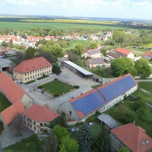 HecklingenFerienwohnung Landwirtschaftliches Gut Taentzler的屋顶上太阳能电池板的学校空中景观