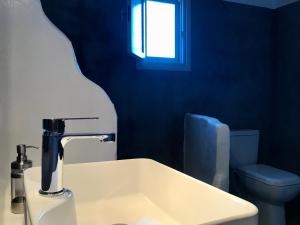 法罗斯岛卡浦纳珀斯公寓的一间带水槽和卫生间的浴室以及窗户。