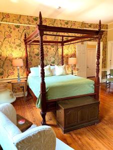 伯灵顿百合宾馆 - 伯灵顿的一间卧室配有天蓬床和沙发