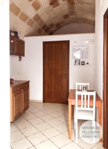 滨海波利尼亚诺Dimora dei Pellegrini的厨房配有桌子和木门